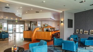 A lobby with a reception desk, blue seating area, and a staircase leading to an upper level. - ACHAT Hotel Heppenheim (Heppenheim)