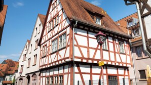 A traditional half-timbered building with a steeply pitched roof, multiple windows, and a visible street lamp. - ACHAT Hotel Heppenheim (Heppenheim)