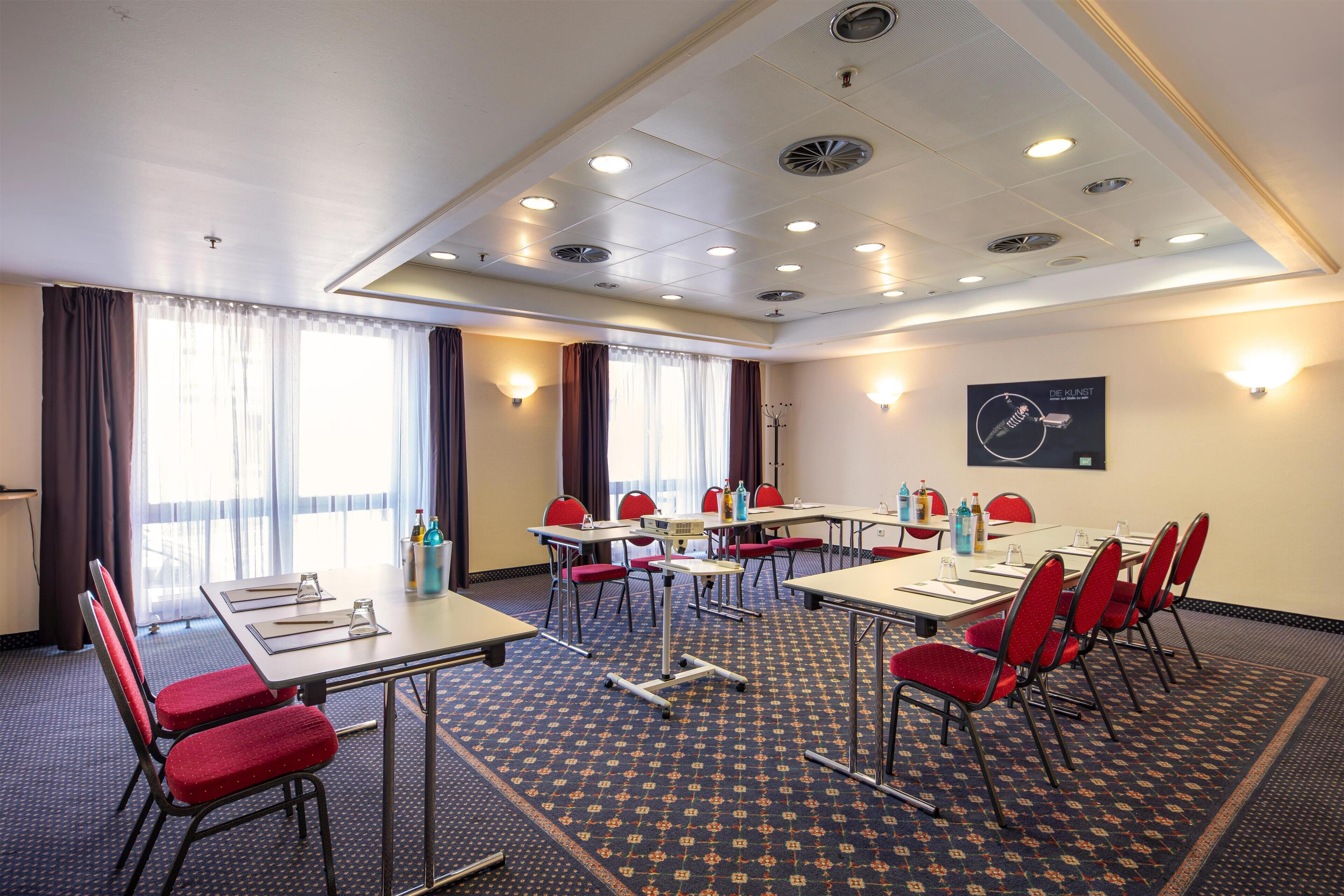 A conference room with tables, chairs, and a clock on the wall.