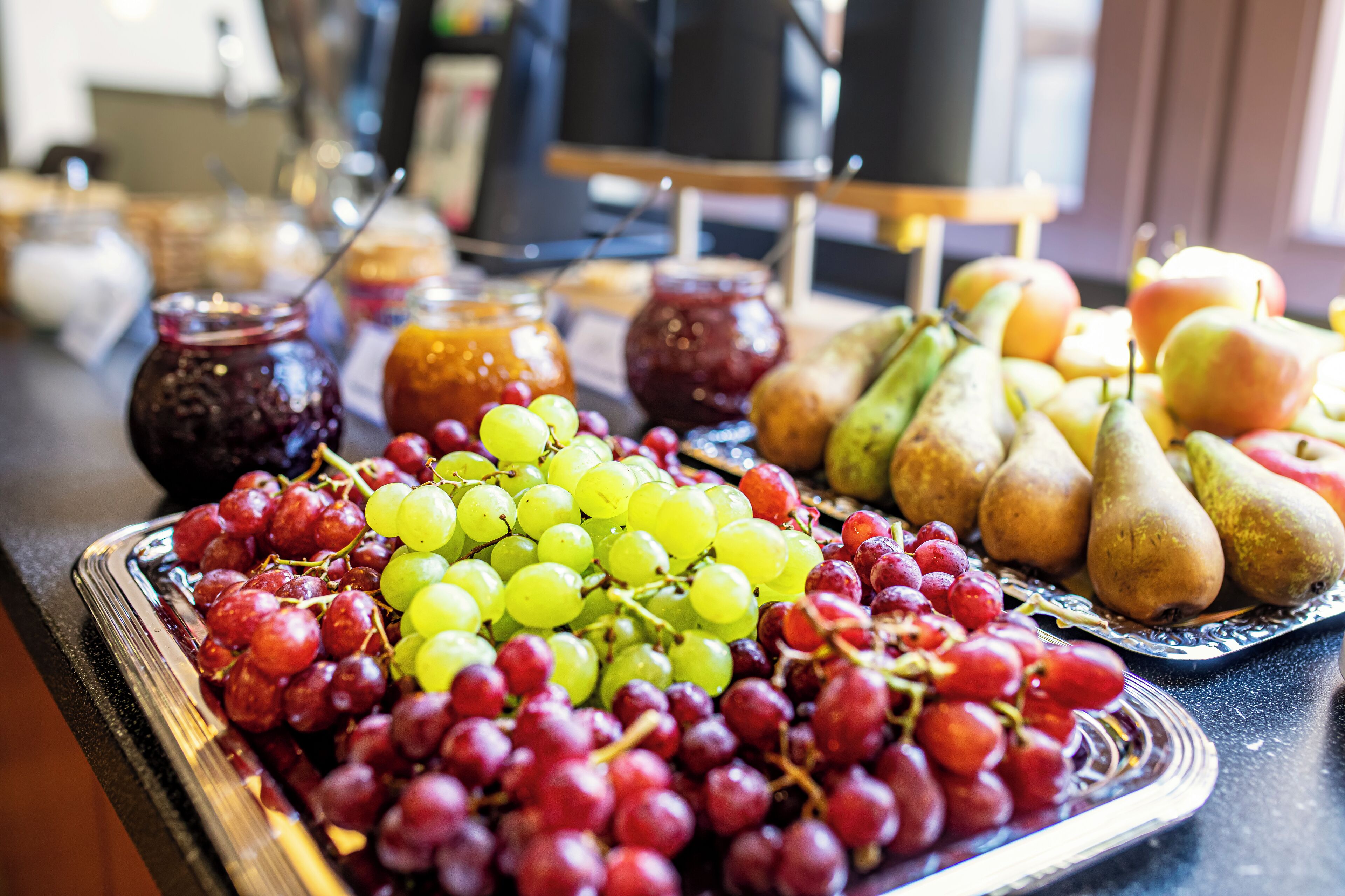 Una bandeja con frutas variadas, como uvas, peras y manzanas.