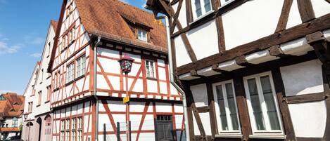 A traditional half-timbered building with a steeply pitched roof and multiple windows.