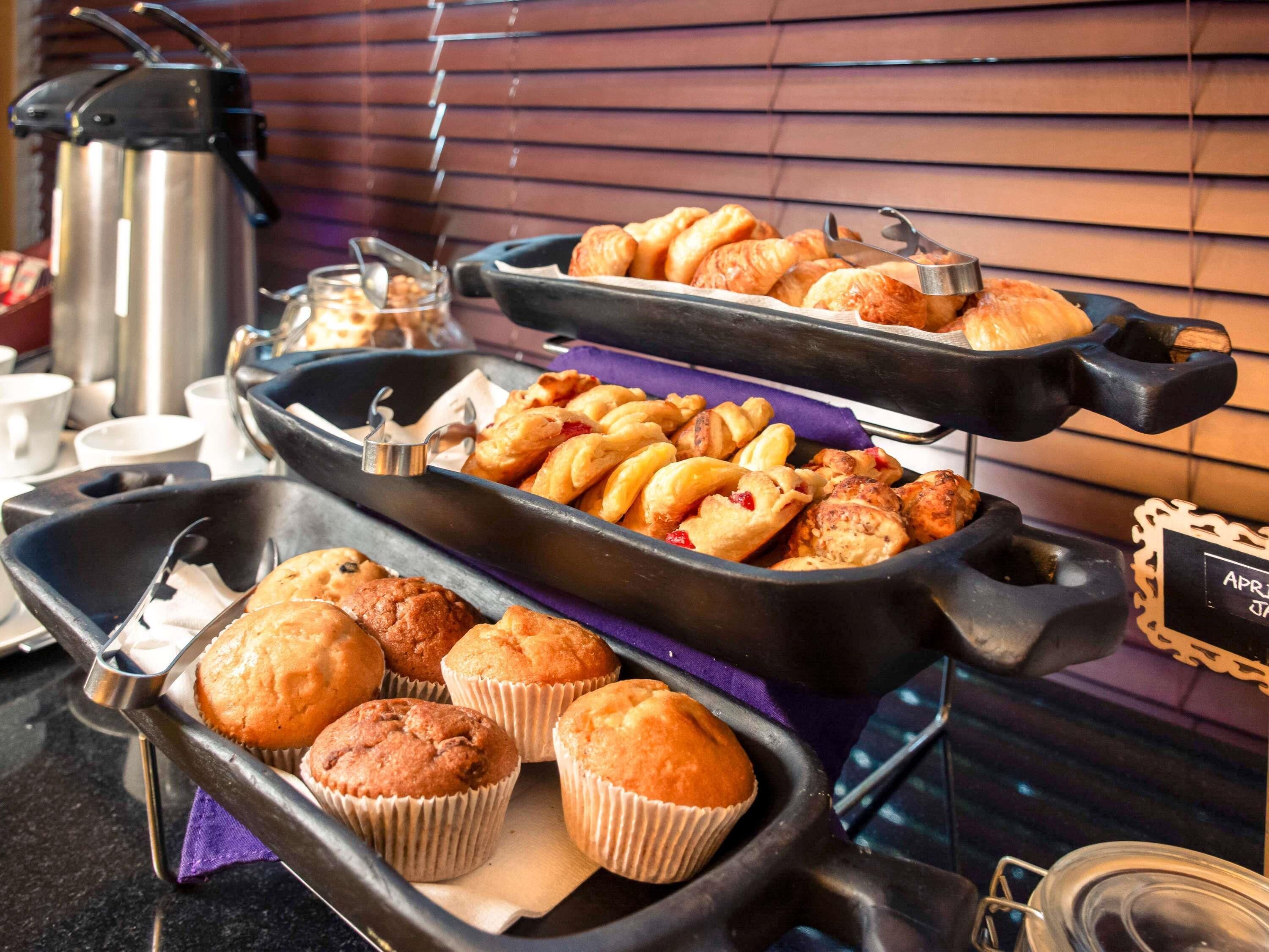 Un buffet proposant une variété de produits de boulangerie, notamment des muffins et des pâtisseries.