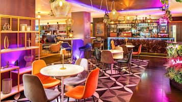 Uma área de bar moderna com mesas redondas e cadeiras laranja, um balcão com letreiro de neon e prateleiras com diversos objetos.