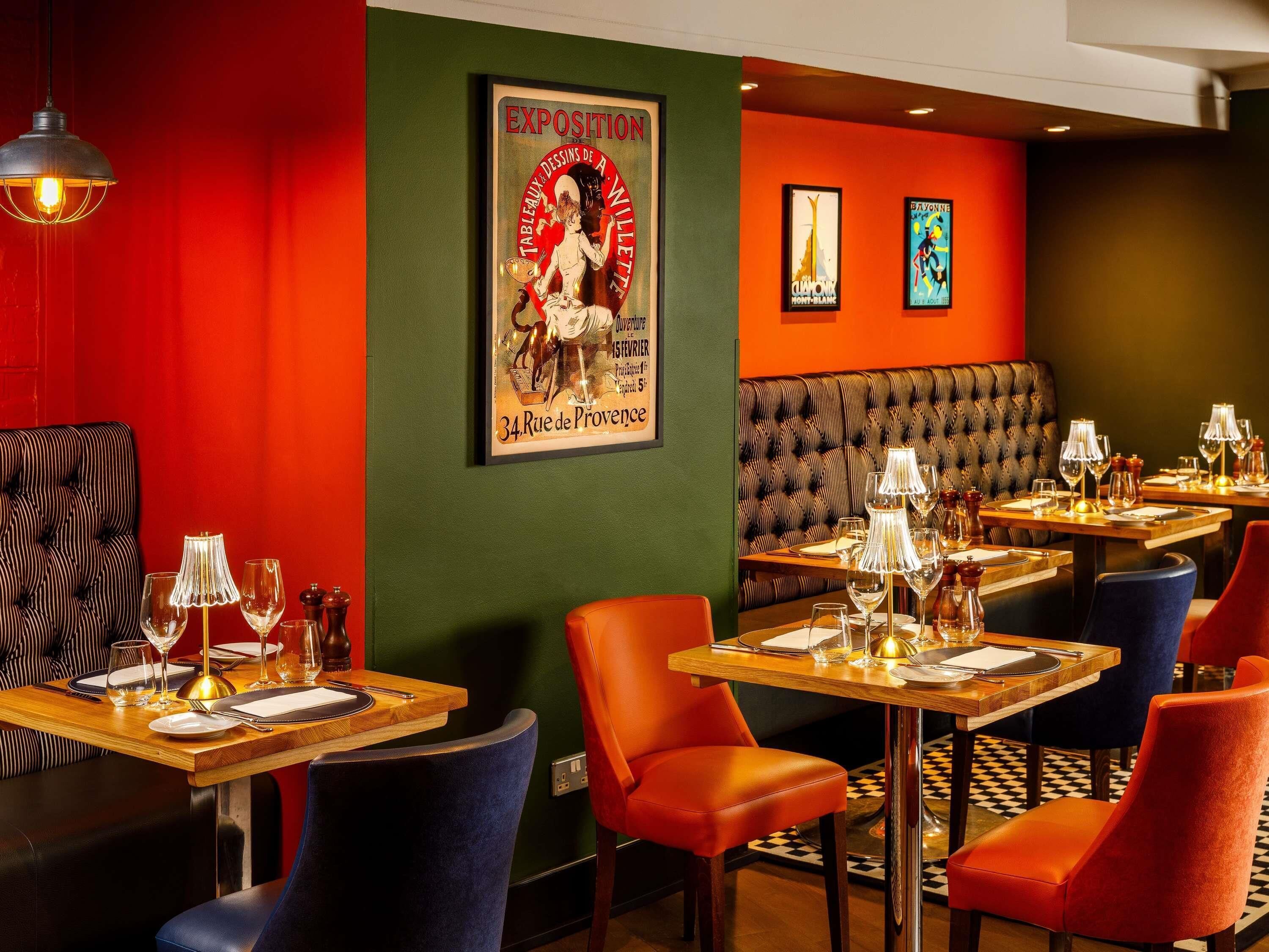 A restaurant interior with booths, tables, and a vintage poster on the wall.