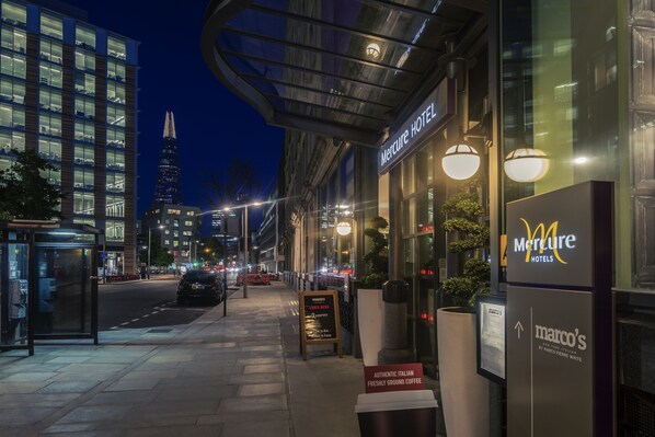 A Mercure Hotel with a modern glass facade, a visible sign for Marco's Italian coffee, and a city street view at night. - Mercure London Bankside (London)