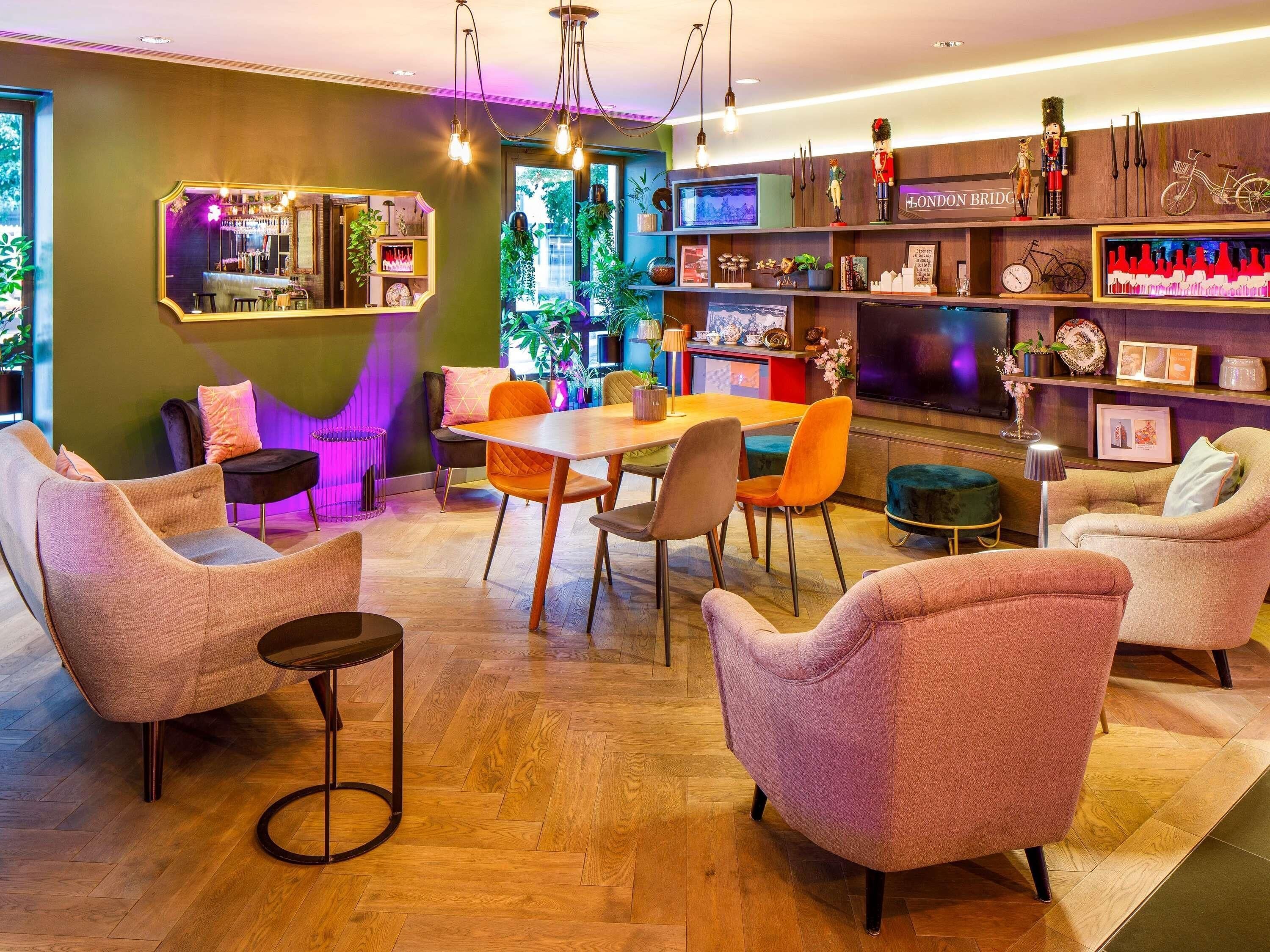 Un saló modern amb zona de bar, seients i televisió.