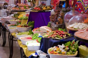 A buffet table with various food items and a decorative centerpiece. - Manazel Ajyad Hotel By Elaf (Makkah)