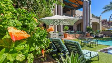 Alberca al aire libre, sombrillas en la alberca y camastros