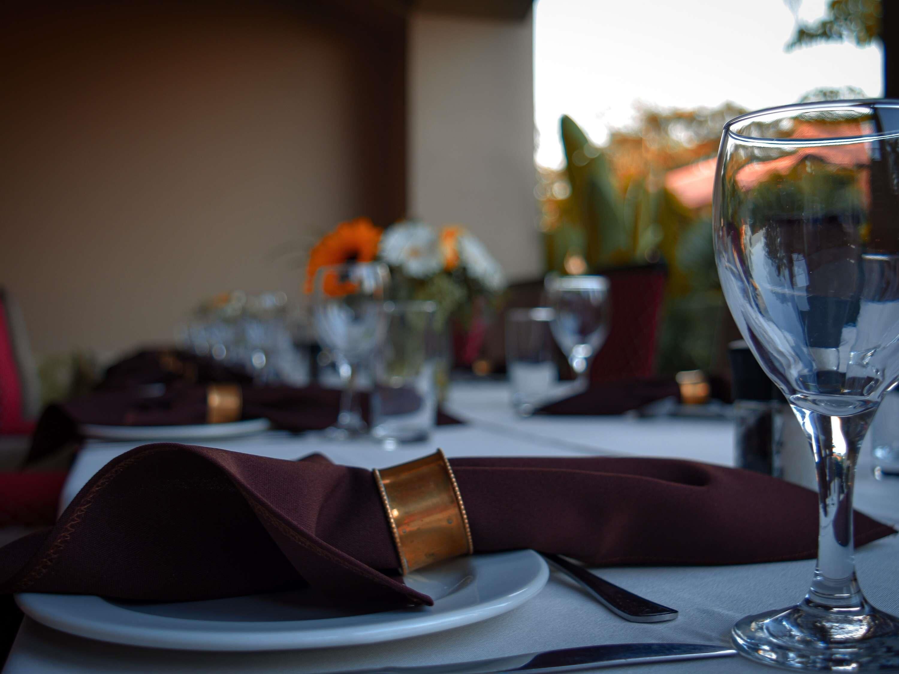 A table set for dining with a wine glass, a folded napkin, and a knife.