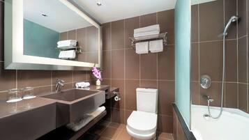 Een moderne badkamer met een dubbele wastafel, toilet en ligbad.