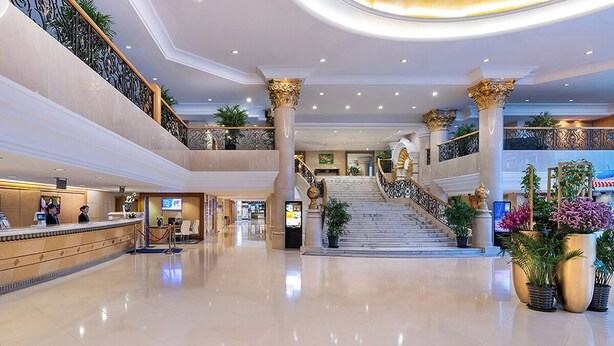 A spacious lobby with a reception desk, a staircase, and multiple levels. - Peace Hotel Beijing (Beijing)