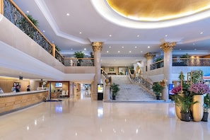 A spacious lobby with a reception desk, a staircase, and multiple levels. - Peace Hotel Beijing (Beijing)