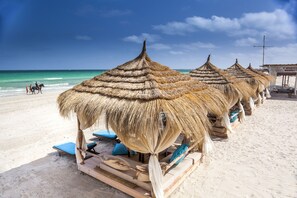 Sur la plage, chaise longue, parasol, serviettes de plage