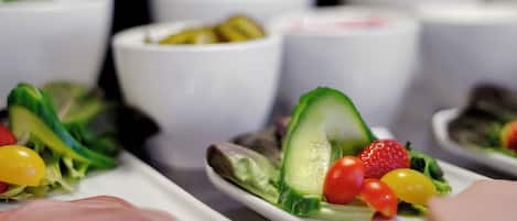 A variety of food items, including salads and dips, arranged on white plates.