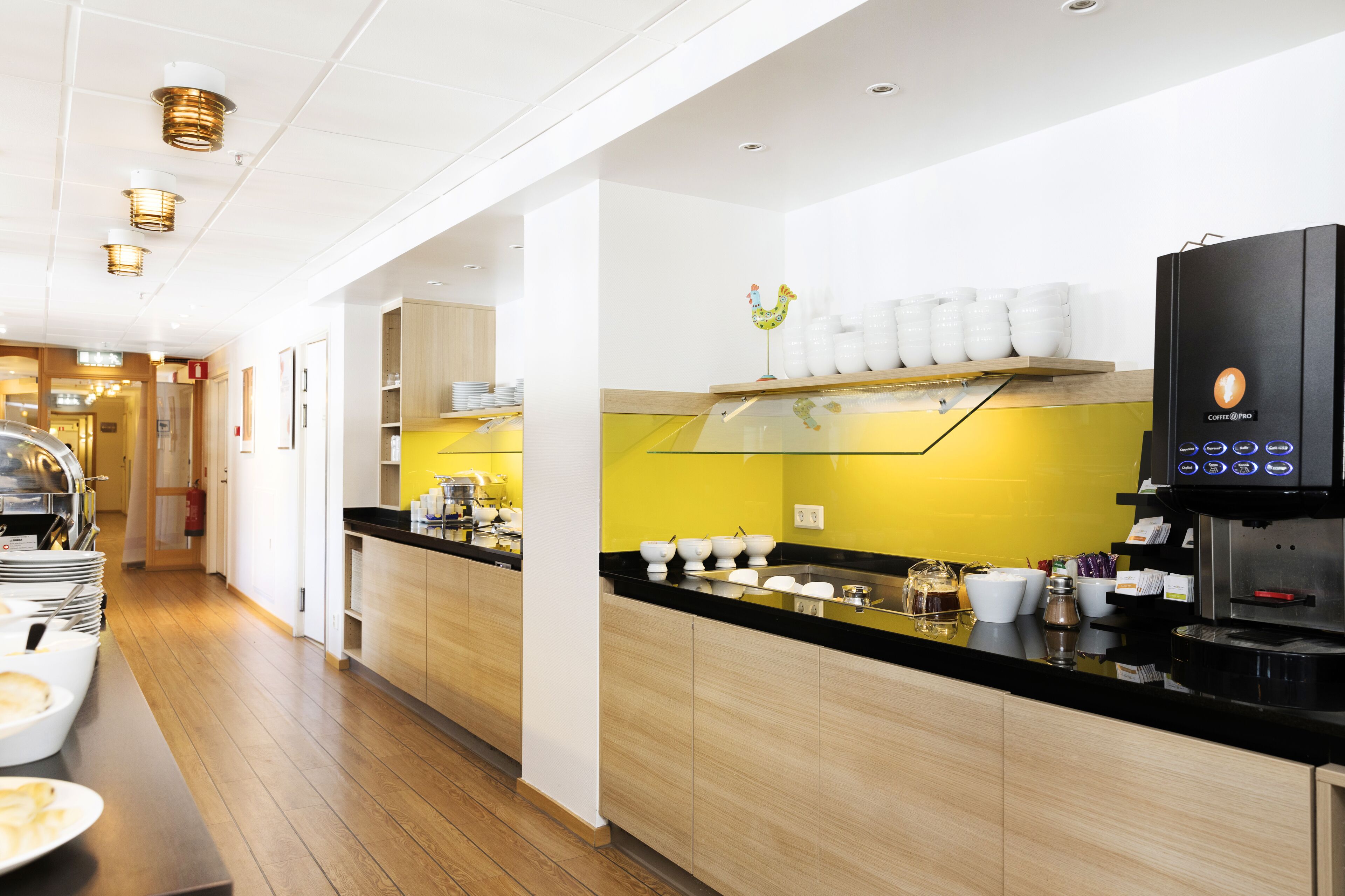 A modern kitchen with a black countertop, white cabinets, and a coffee machine.