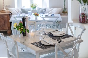 Enjoy a warm and inviting dining experience with a beautifully set table, complete with fine china and a candle.