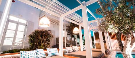 A modern outdoor lounge area with seating and a pool.