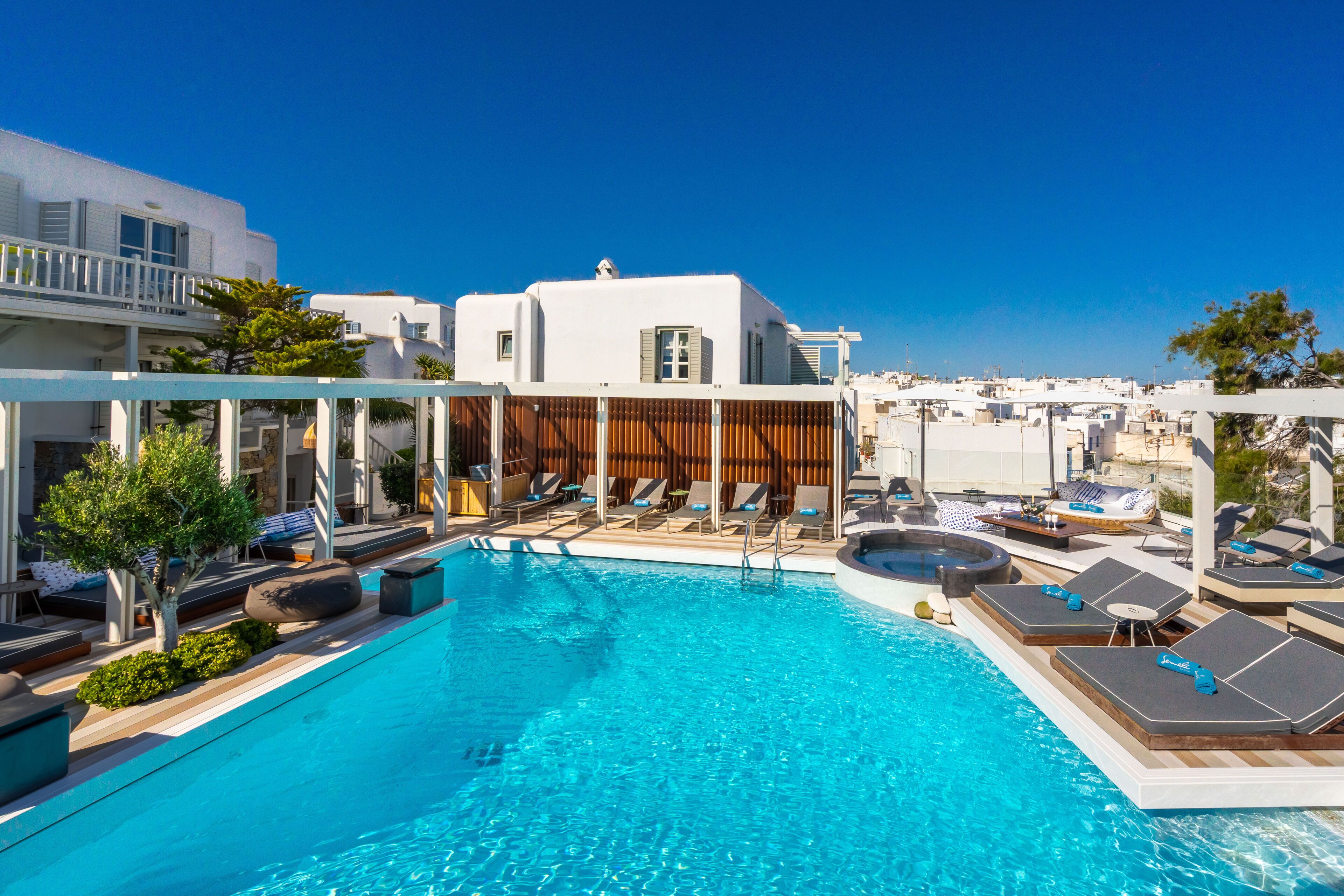 A swimming pool with lounge chairs and a wooden deck area.
