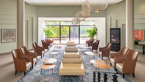 A spacious lobby with a central seating area, large windows, and a modern chandelier. - Riviera by Isrotel Collection (Eilat)