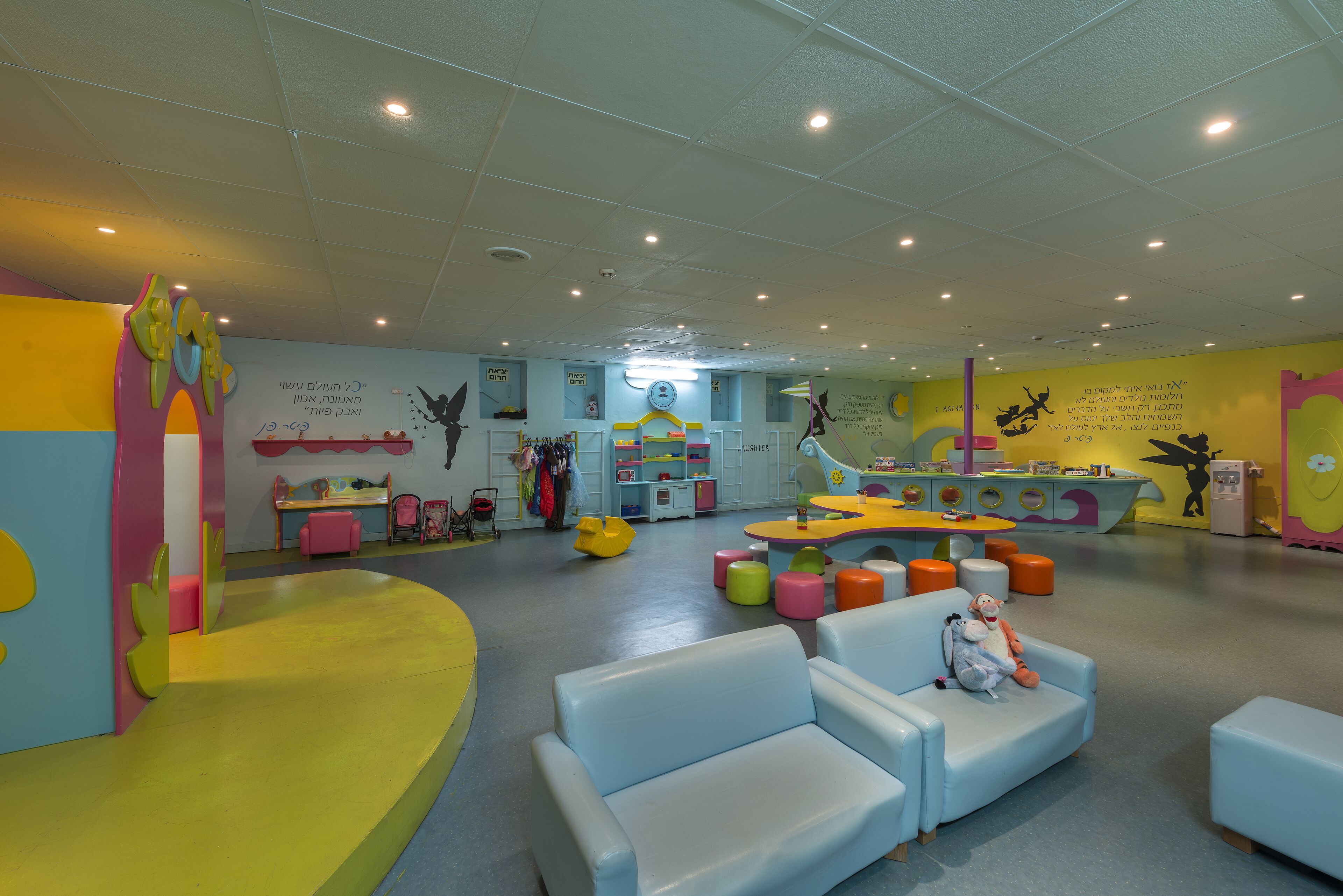 A brightly colored children's play area with seating and play tables.