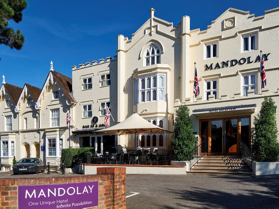 A large, historic building with a sign reading "MANDOLAY HOTEL RECEPTION".