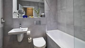 Un baño moderno con lavamanos, inodoro y bañera.