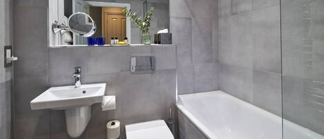 Un baño moderno con lavamanos, inodoro y bañera.