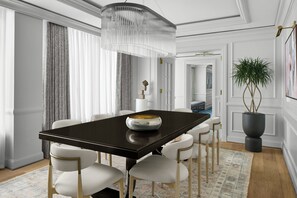 Une salle à manger moderne avec une table en bois foncé, des chaises à revêtement blanc, un bol décoratif et une grande plante en pot.