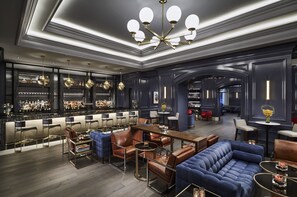 A modern bar area with leather seating, a chandelier, and a well-stocked liquor display. - The Ritz-Carlton, Washington, D.C. (Washington)
