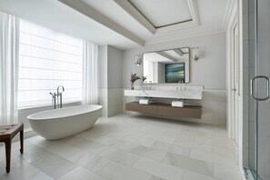 A modern bathroom with a freestanding bathtub, a large mirror, and a glass-enclosed shower.