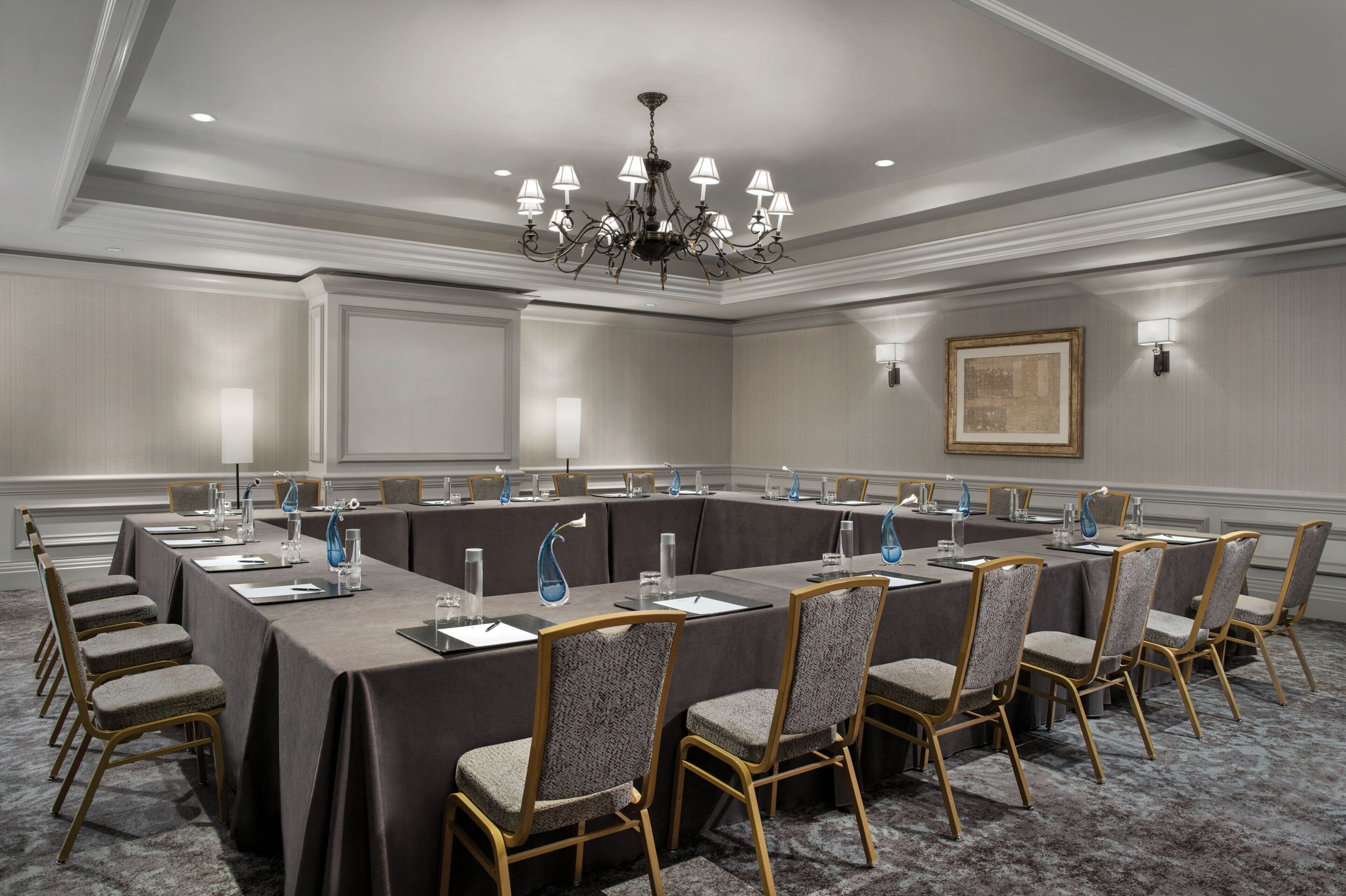 A conference room with a long table, chairs, and a chandelier.