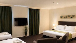 A hotel room with two beds, a TV, a desk, and a chair. - The Richmond Hotel - Adelaide (Adelaide)