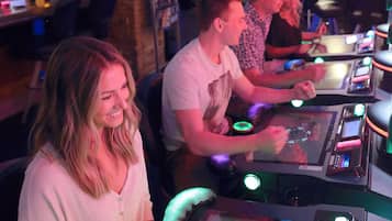 A gaming area with multiple gaming machines and people playing.