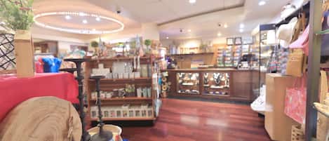 A well-lit store with wooden flooring, shelves stocked with various items, and a central display area.
