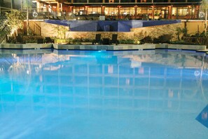 A swimming pool with a stone wall and lounge chairs. - Treasure Bay Casino and Hotel - Adults Only (Biloxi)
