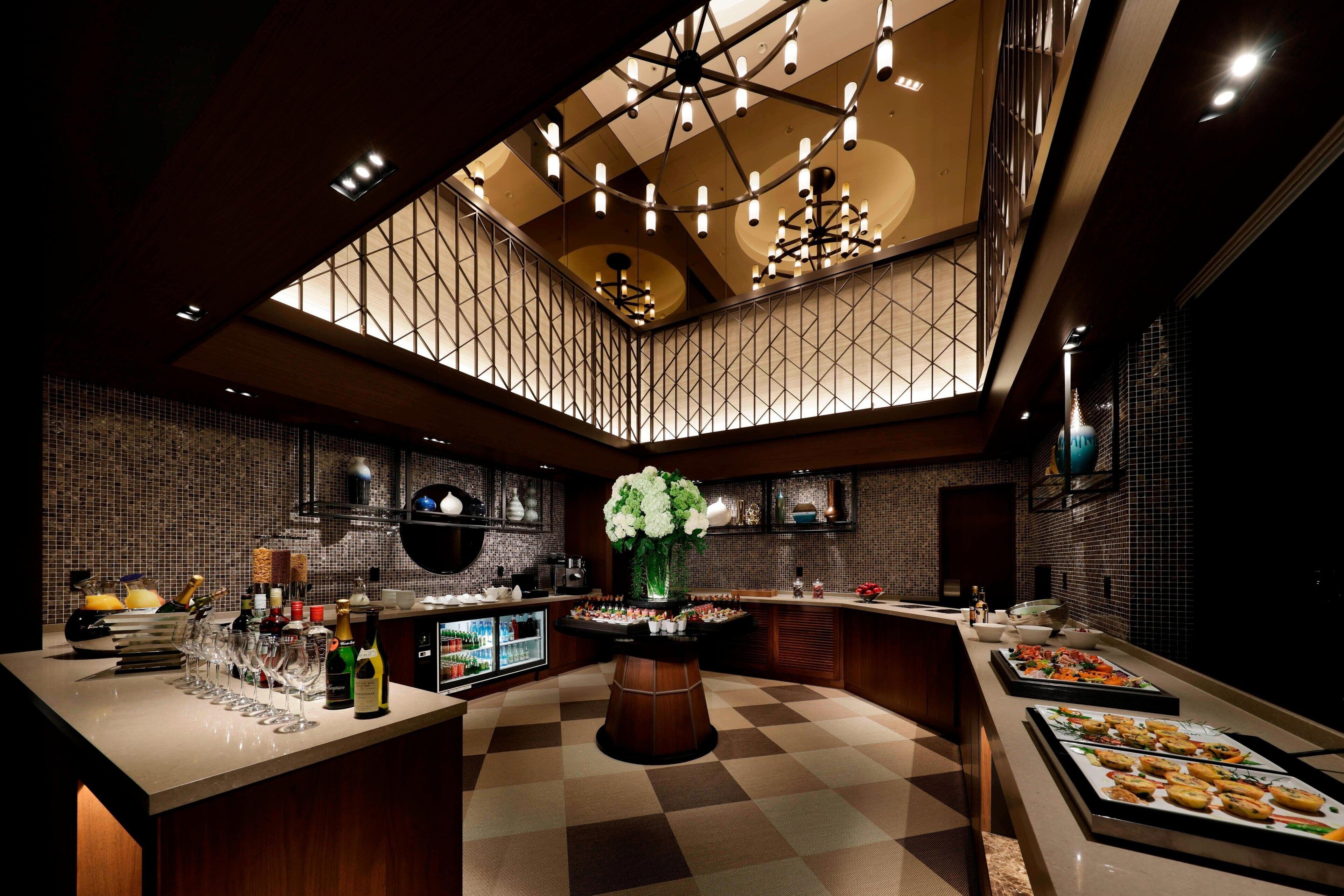 A modern kitchen with a central island, a wine cooler, and a variety of food items displayed on the counter.