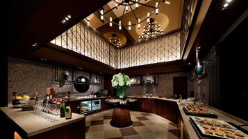 A modern kitchen with a central island, a wine cooler, and a variety of food items displayed on the counter.