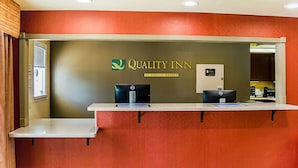 A reception desk with a sign for Quality Inn by Choice Hotels, a desk phone, and a computer. - Quality Inn Vicksburg (Vicksburg)