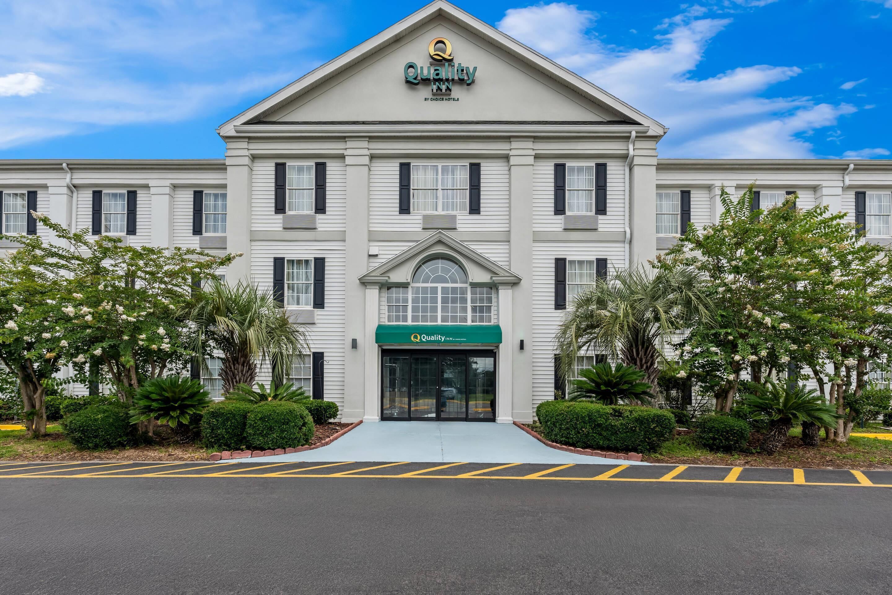 A hotel with a symmetrical facade, a central entrance, and a sign indicating it is a Choice Hotel.