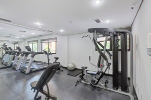 A gym with treadmills, a weight machine, and a mirrored wall.