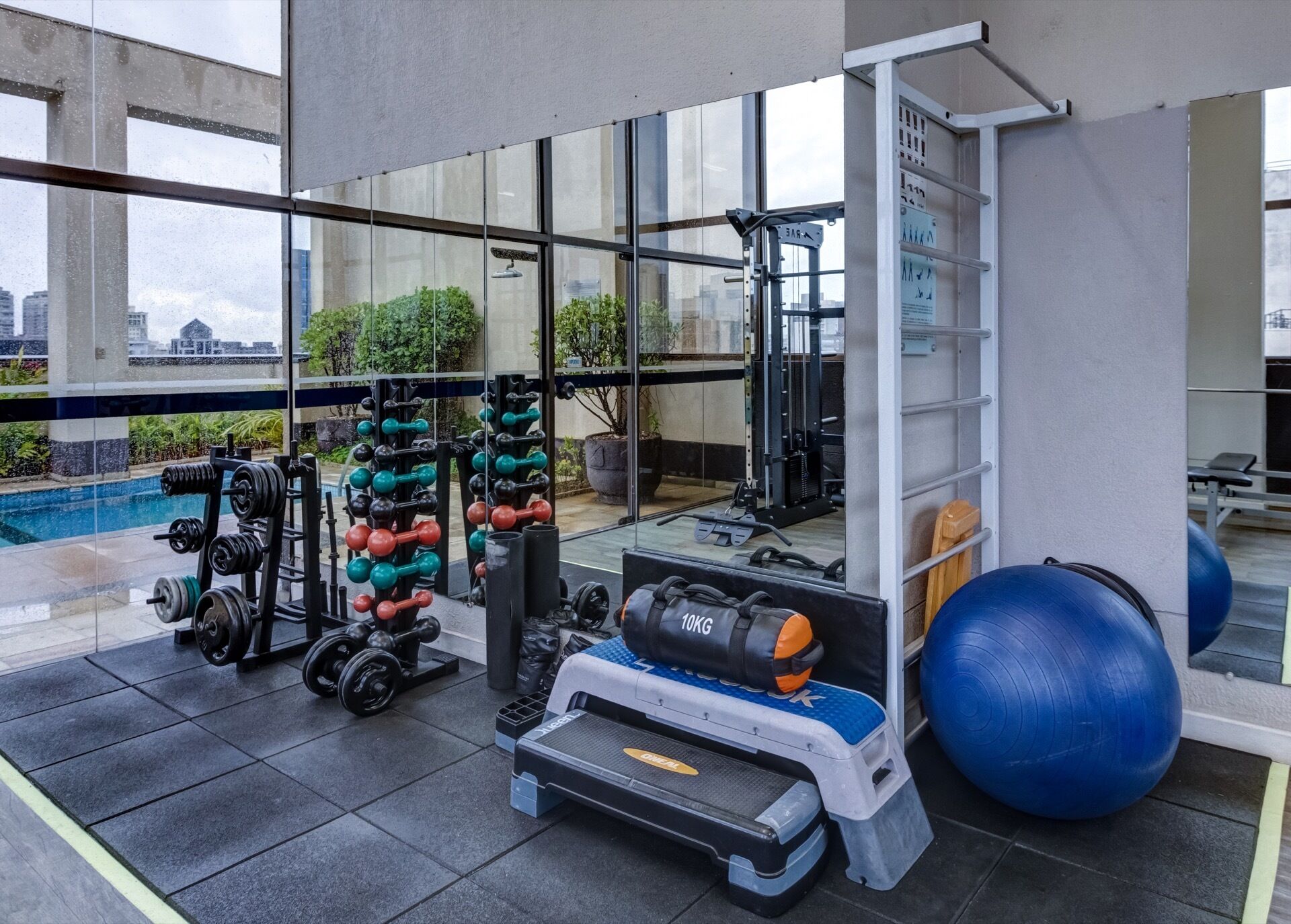 A gym with weightlifting equipment, a step platform, and exercise balls.