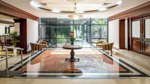 A spacious lobby with a marble floor, a central round table, and seating arrangements. - Melia Lima (Lima)