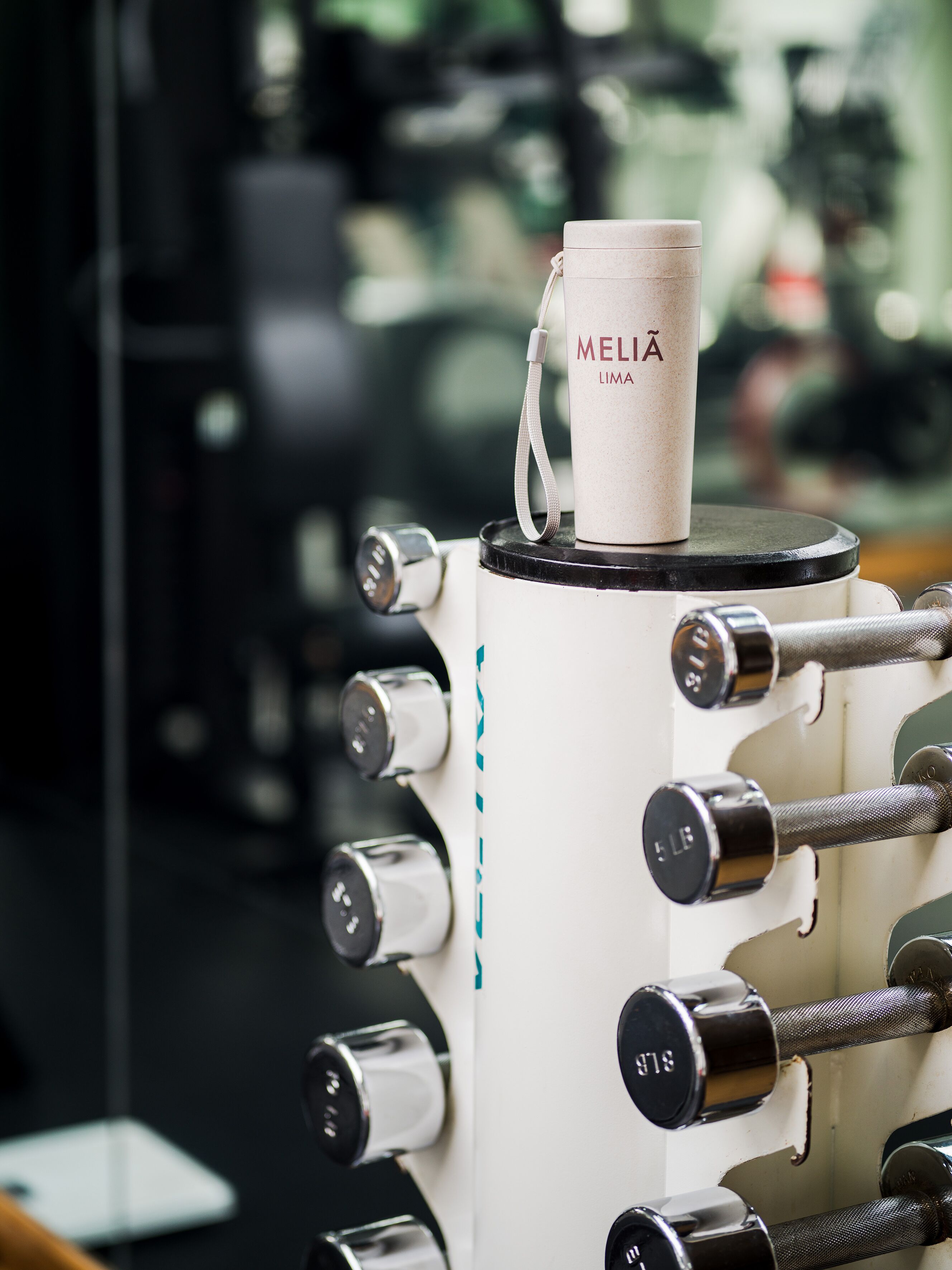 A coffee machine with a cup labeled "MELIA LIMA" on top.