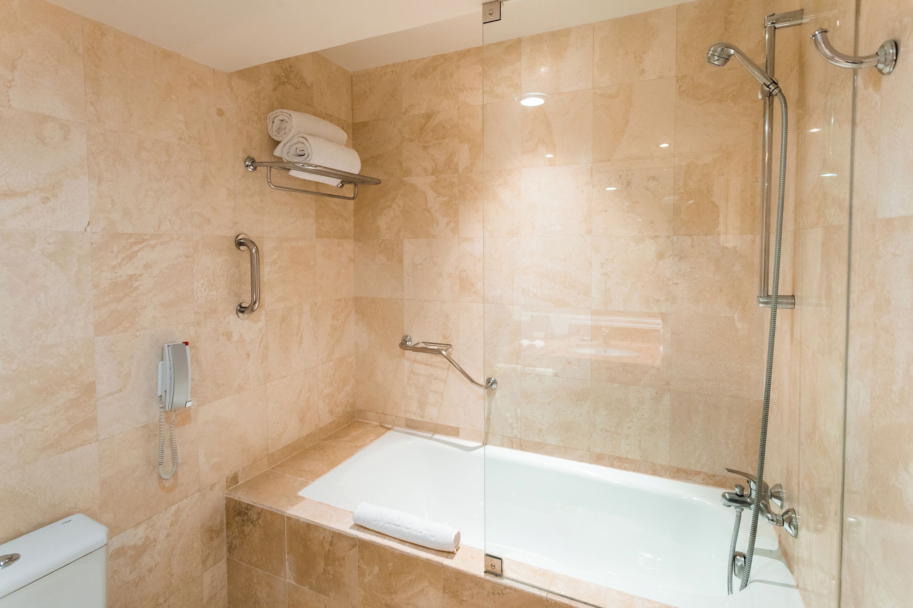 A modern bathroom with a bathtub, a shower, and a toilet.