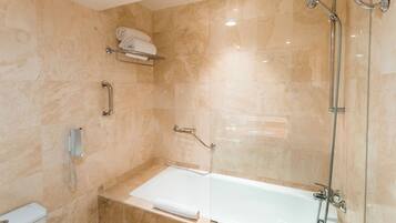 A modern bathroom with a bathtub, a shower, and a toilet.