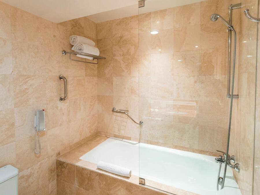 A modern bathroom with a bathtub, a shower, and a toilet.