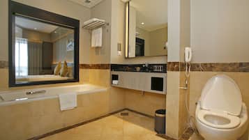 A modern bathroom with a large mirror, a bathtub, a toilet, and a shower.