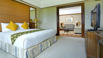 A hotel room with a large bed, a television, and a desk.
