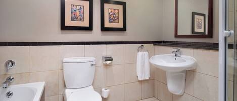 A bathroom with a toilet, sink, and bathtub. There are two framed pictures on the wall.
