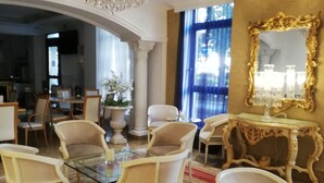 Una habitación lujosa con muebles elaborados, un candelabro y un espejo grande.